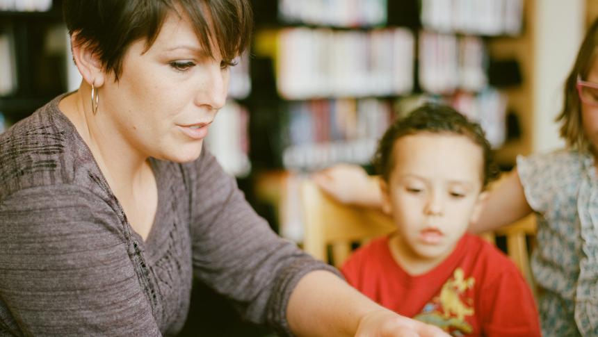Teacher and young student reading