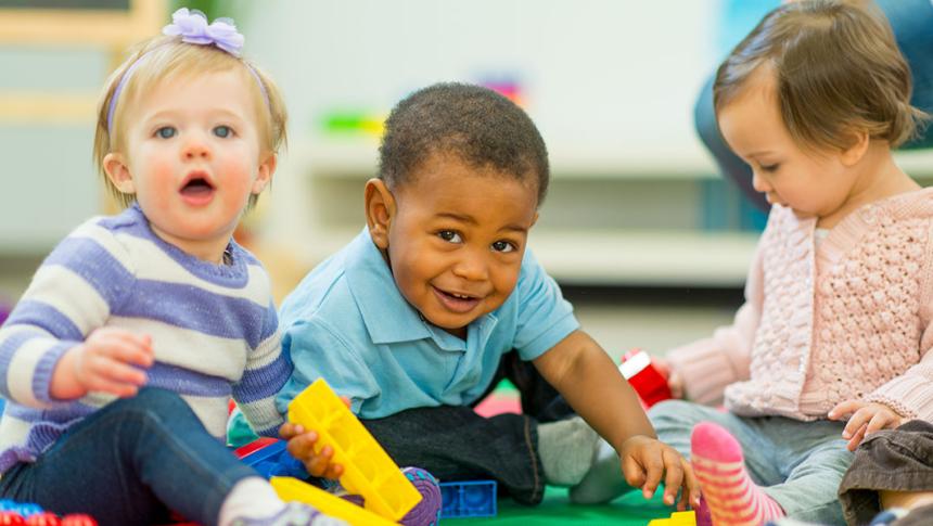 Three children sit and play together