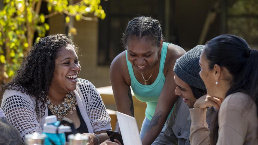 Adult and three teenagers sitting at a table