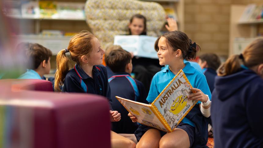 two students reading a picture book