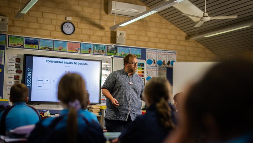A teacher stands in front of his class.
