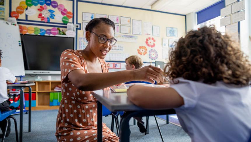 A teacher sits and talks to a student