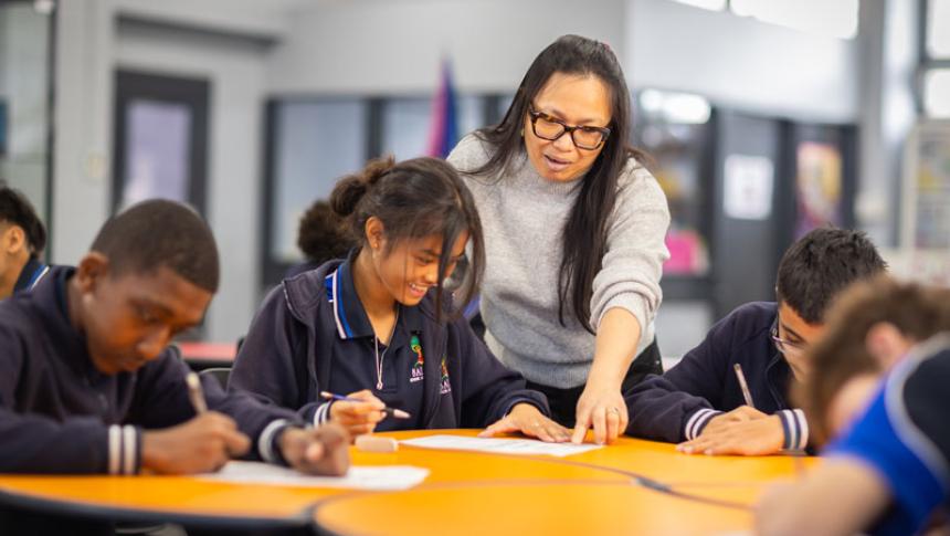 A teacher helping a student. 