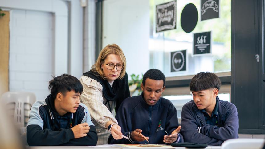 teacher in class with three boys