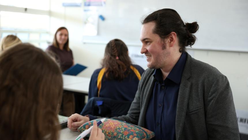 A teacher having a friendly discussion with his high school class