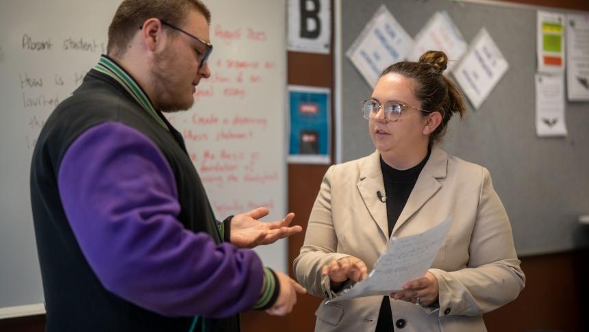 Two teachers discuss a written document in a school setting