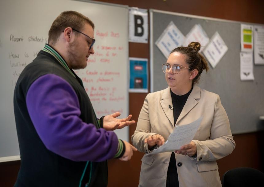 Two teachers discuss a written document in a school setting